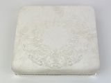 an antique silver box with a floral design on the lid