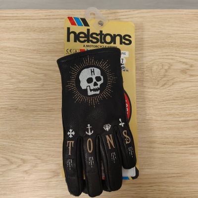 un gros plan sur une paire de gants noirs ornés d'un crâne