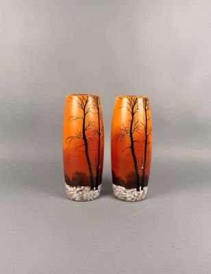 une paire de vases orange ornés d'arbres sur fond gris