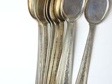 five spoons and a spoon rest on a white surface