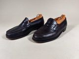 a pair of black loafers on a white background