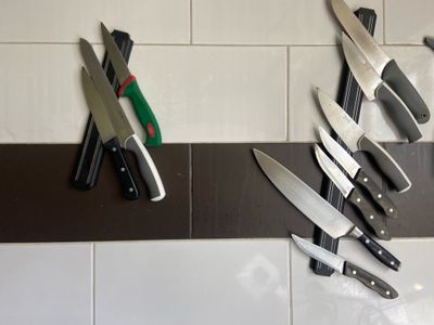 de nombreux couteaux accrochés au mur de la cuisine