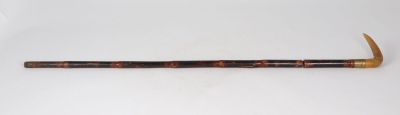 an old wooden stick with a wooden handle on a white surface