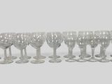 many wine glasses lined up in a row on the table
