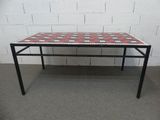 une table à carreaux rouges et blancs posée sur un sol en béton