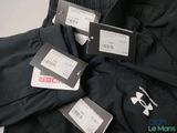three men ' s under armour pants with tags on them sitting on a table