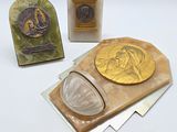 trois œuvres d'art en verre et une plaque sur un fond blanc