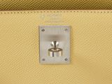 a close up of a yellow purse with a ring on it