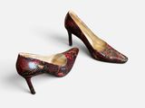 une paire d'escarpins rouges en peau de serpent à bout pointu