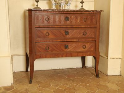 une petite commode sur laquelle est posé un vase