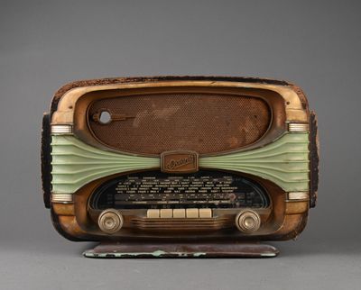 an old radio sitting on top of a wooden stand