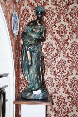 une statue représentant une femme tenant un bébé dans ses bras, posée sur un socle