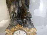 a statue of an angel holding a child and a clock