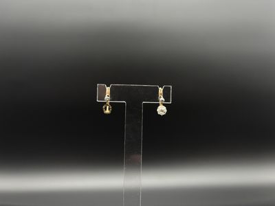 gros plan d'une paire de boucles d'oreilles sur un support