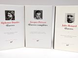 trois livres posés sur une table blanche, avec la photo d'un homme et d'une femme