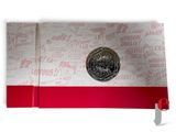 a silver coin sitting on top of a red ribbon
