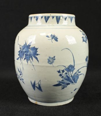 un vase bleu et blanc posé sur une surface noire