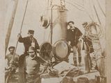 a black and white photo of a group of men on a boat