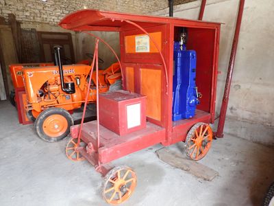 un petit chariot rouge avec une boîte bleue à l'arrière