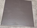grey square tile on the floor with a white wall in the background