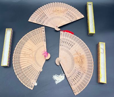 a lot of different types of hand fans on the table