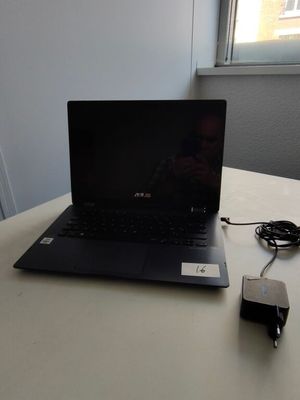 a laptop computer sitting on a table with a charger