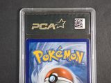 the pokemon card is in a plastic case on a black surface
