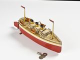 une petite maquette de bateau posée sur une surface blanche
