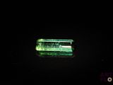 un gros plan d'un morceau de verre vert posé sur une surface noire