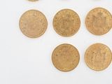 several gold coins are arranged in a row on a white surface