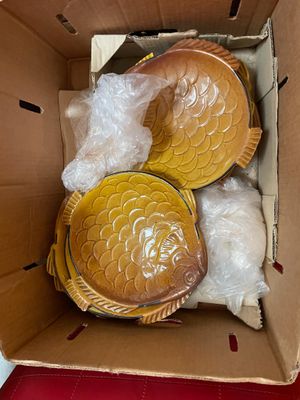 a cardboard box with two fish shaped dishes inside of it