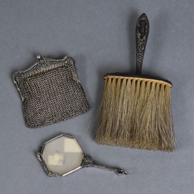 a brush, mirror, and purse sitting on a table