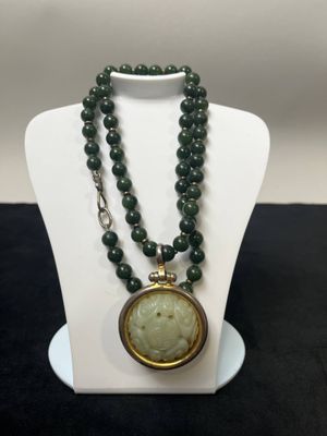 un gros plan sur un collier porté par un mannequin, avec la photo d'une femme