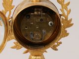 a gold clock that is sitting on top of a table