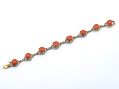 un gros plan d'un bracelet orné de perles orange sur un fond blanc