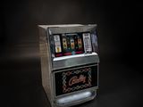 une vieille machine à sous posée sur une table dans une pièce sombre