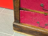 une commode rouge avec deux tiroirs dans une pièce