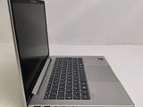 a silver laptop with a black keyboard on a white surface