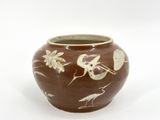 a brown and white vase with birds and flowers on it
