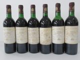 six bottles of wine are lined up in a row on a white surface