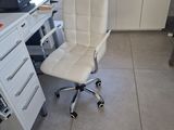 a desk with a computer and a chair in the room