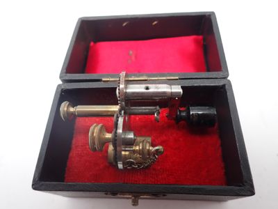 une boîte contenant un pistolet, posée sur un tissu rouge