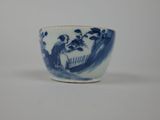a blue and white cup with a picture of people in a garden