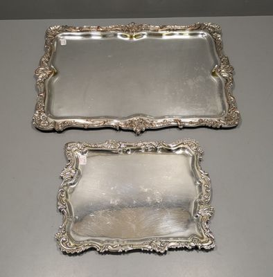 deux plateaux en argent munis d'anses, posés sur une table