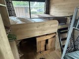 a bunk bed in the corner of a room with a ladder