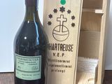 une bouteille de vin à côté d'une caisse en bois sur une table