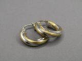 boucles d'oreilles créoles bicolores, or et argent, sur un fond gris