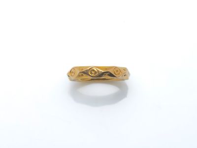 gros plan d'une bague en or sur une surface blanche