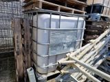 un grand conteneur blanc posé sur une pile de palettes en bois