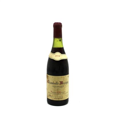 an old bottle of wine sitting on top of a white surface
